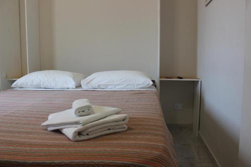 a bedroom with a bed with towels on it at Nova Home in Catania