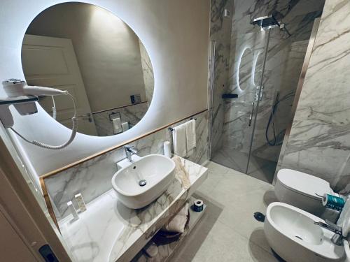 a bathroom with a sink and a mirror and a toilet at Palazzo Bonomi in Bisceglie