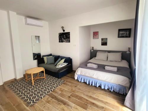 ein Schlafzimmer mit einem Bett und einem Sofa in der Unterkunft Villa-nova avec spa à 5 minutes des remparts. in Avignon