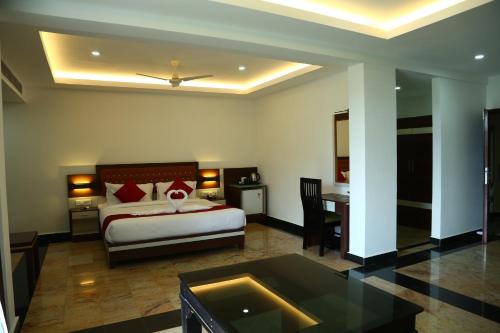 a bedroom with a bed and a desk and a bed and a table at Hotel Idukki Castle in Idukki