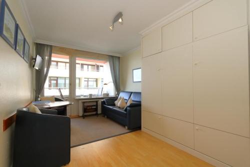 een woonkamer met een bank en een tafel bij Haus-am-Meer-App-56 in Westerland