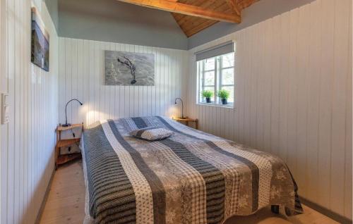 Un dormitorio con una cama con una manta. en Nice Home In Rrvig With 3 Bedrooms And Wifi en Rørvig