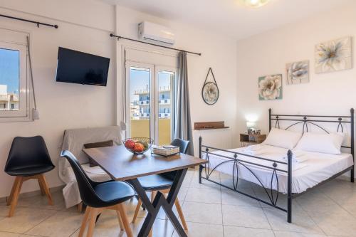 um quarto com uma cama, uma mesa e uma sala de jantar em Studio on the closest beach to the city! em Amoudara Herakliou
