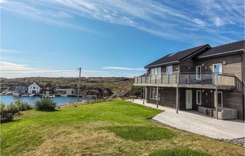 a house with a large yard next to a body of water at Nice Home In Bremnes With Wifi in Bremnes