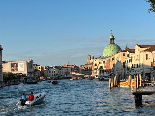 two people in a boat on a river with buildings at Venice Luxury Suite - Private Jacuzzi and Design in Venice