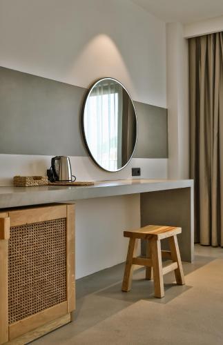 a bathroom with a mirror and a wooden stool at Carruba Boutique Hotel in Kas