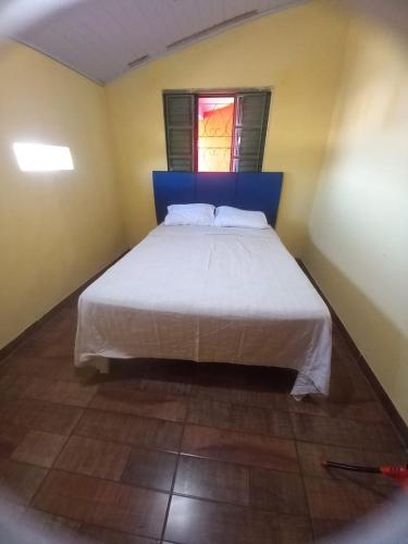 een slaapkamer met een bed met een blauw hoofdeinde en een raam bij Hostal los lobos. in Ciudad del Este