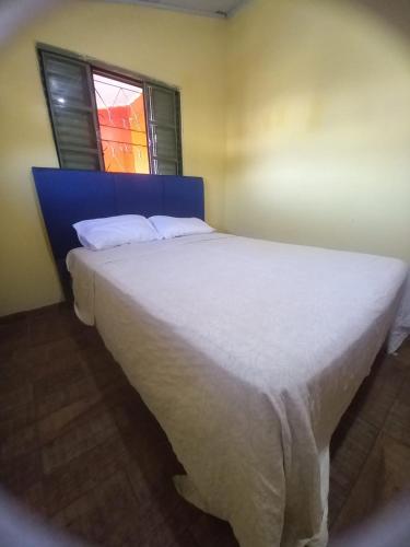 a large white bed in a room with a window at Hostal los lobos. in Ciudad del Este