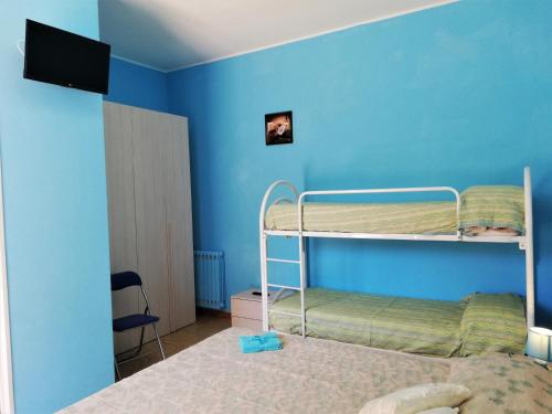リポストにあるVia Pisaの青い壁の客室で、二段ベッド2組が備わります。