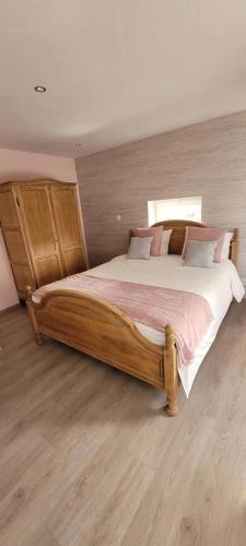 - une chambre avec un grand lit en bois et des draps roses dans l'établissement Il Vialetto, appartement Santa Lucia, au calme, tout confort, à Jeumont