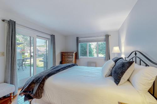 een slaapkamer met een groot bed en een balkon bij Après Ski Haven in Quechee