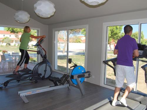un homme et une femme faisant de l'exercice dans une salle de sport dans l'établissement Holiday Home in France with Garden Terrace, à Torreilles