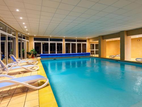 - une grande piscine avec des chaises dans une chambre d'hôtel dans l'établissement Apartment in Fréhel near Cap Fréhel, à Fréhel
