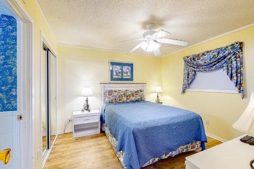een slaapkamer met een blauw bed en een plafondventilator bij Myrtle Beach Resort A-332 in Myrtle Beach