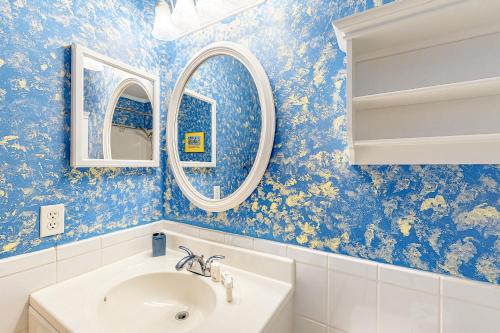 een badkamer met blauwe muren en een wastafel en spiegels bij Myrtle Beach Resort A-332 in Myrtle Beach