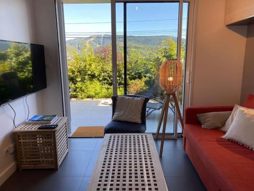 a living room with a red couch and a large window at Appartement Gérardmer in Gérardmer