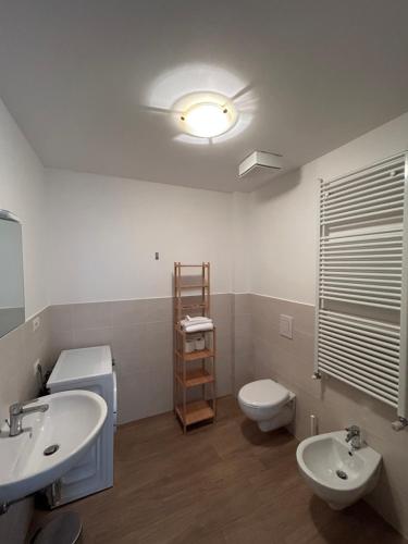 a bathroom with two sinks and a toilet and a light at Agriturismo Poggio Ajano in Abbazia di Santa Maria in Selva
