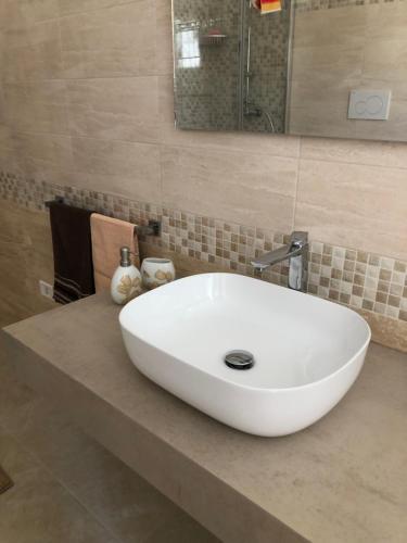 a bathroom with a white sink and a mirror at La Marchesa di Castiglione in Andrano