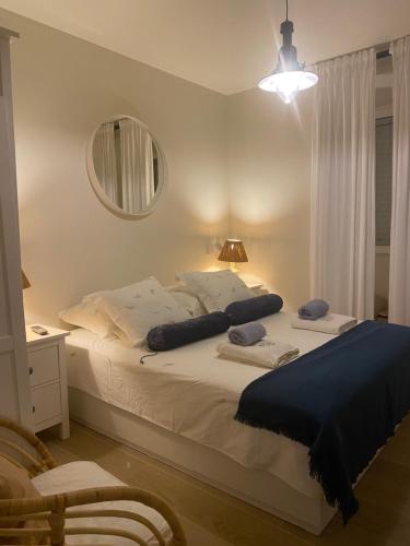 een slaapkamer met een groot wit bed en een spiegel bij La Casetta di Gloria in Lumbarda