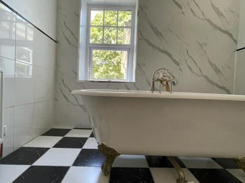 a white bath tub in a bathroom with a window at Northampton House in Llanwrtyd Wells