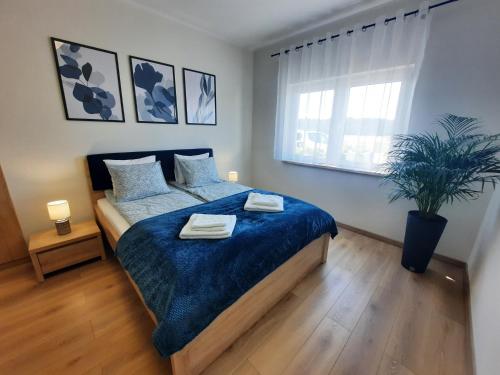 1 dormitorio con 1 cama con 2 toallas en Chabrowa Apartamenty 1, en Milicz