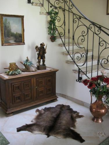 a living room with a staircase and a vase of flowers at Pension Schlömmer in Sankt Gilgen