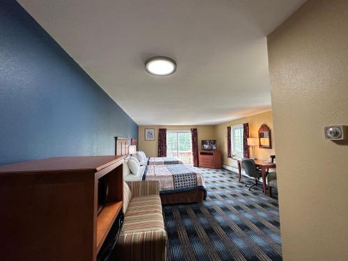 a hotel room with a bed and a bed and a couch at Swiss Chalets Village Inn in North Conway