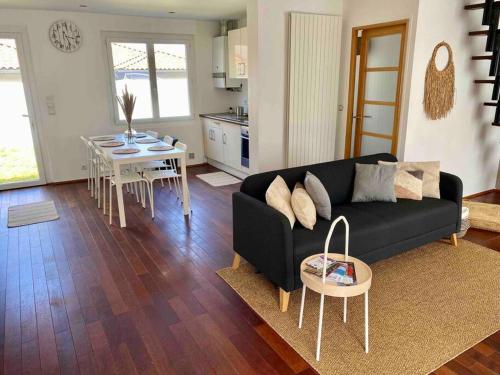 a living room with a black couch and a table at Superbe Maison - Biarritz/Plage in Biarritz