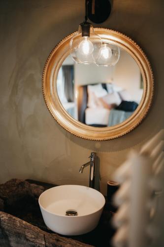 a bathroom with a white sink and a mirror at La Villa Ava in Somme-Leuze
