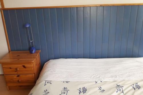 a bed in a room with a blue wall at Découvrir le Finistere depuis MA Maison lumineuse calme et ZEN in Landerneau