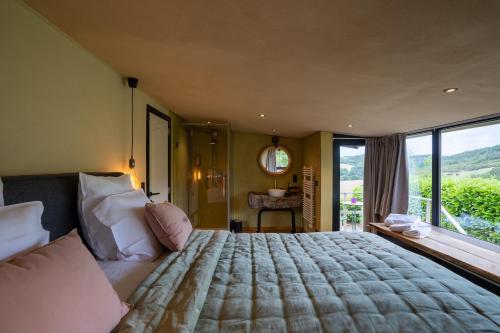 um quarto com uma cama grande e uma janela grande em La Villa Ava em Somme-Leuze