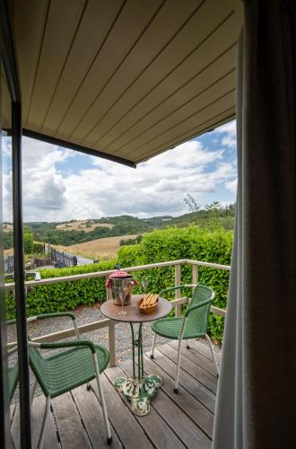 a patio with a table and chairs on a deck at La Villa Ava in Somme-Leuze