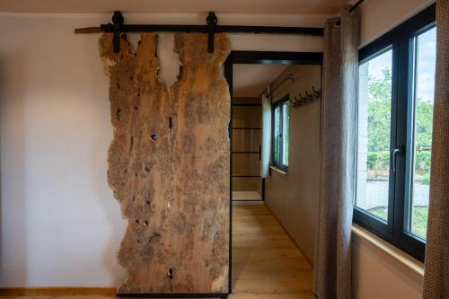 a large wooden door in a room with a hallway at La Villa Ava in Somme-Leuze