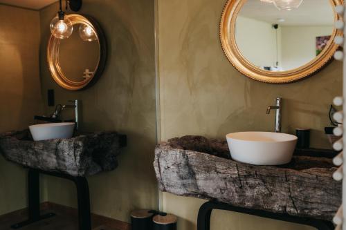 a bathroom with two sinks and a mirror at La Villa Ava in Somme-Leuze