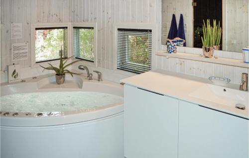 Baño blanco con bañera y lavamanos en 4 Bedroom Nice Home In Gilleleje, en Gilleleje
