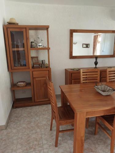 a dining room with a wooden table and a mirror at Le Tamier - Amazing holidays in Flic-en-Flac