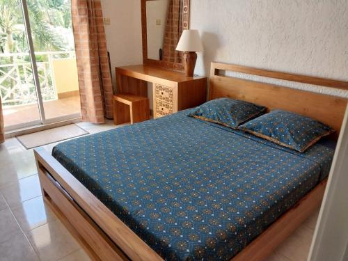 a bedroom with a bed with a blue comforter at Le Tamier - Amazing holidays in Flic-en-Flac