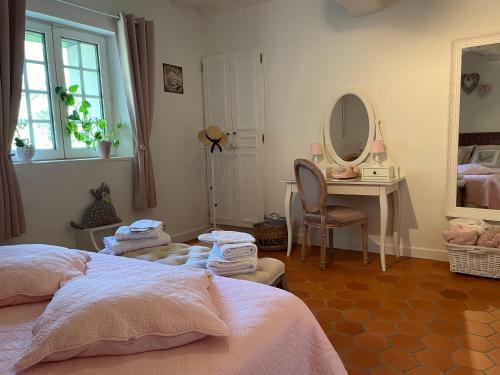 een slaapkamer met 2 bedden, een bureau en een spiegel bij La Parenthèse in Richebourg