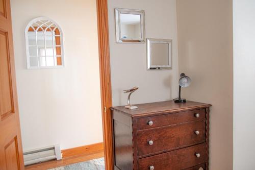 a dresser with a lamp on top of it in a room at Cozy Get Away Somerville in Somerville