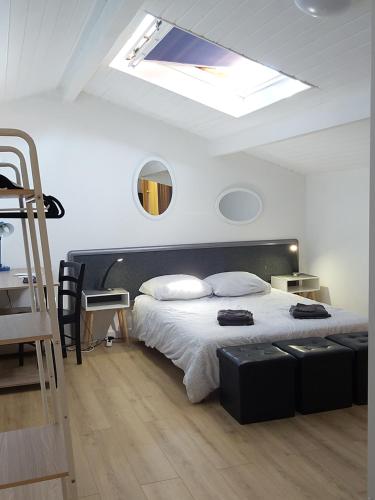 - une chambre avec un grand lit et une lucarne dans l'établissement Appartement 4 personnes vue Océan et Phare de Biarritz, à Anglet