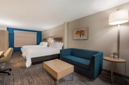 a hotel room with a bed and a blue chair at Holiday Inn Express & Suites Lexington by IHG in Lexington