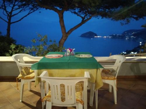 una mesa y sillas con vistas al océano en Hotel Villa al Mare, en Isquia