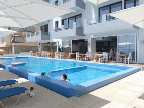two children swimming in a swimming pool in a building at Diamond DREAM in Sarandë