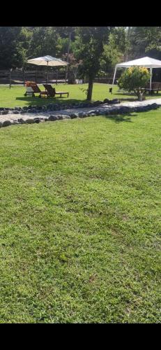 a park with two picnic tables in the grass at Il Rio Grande in Beverino