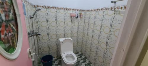 a small bathroom with a toilet and a shower at FAREL HOMESTAY KAWAHIJEN in Banyuwangi