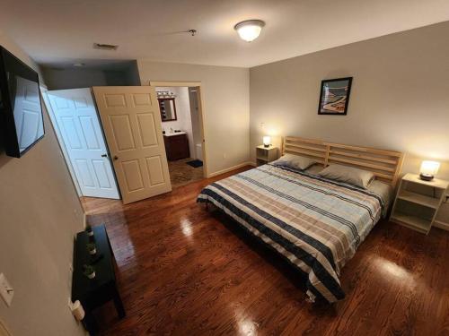 1 dormitorio con 1 cama, 2 lámparas y puerta en Luxury 2 bed apt, mins to NYC!, en Union City