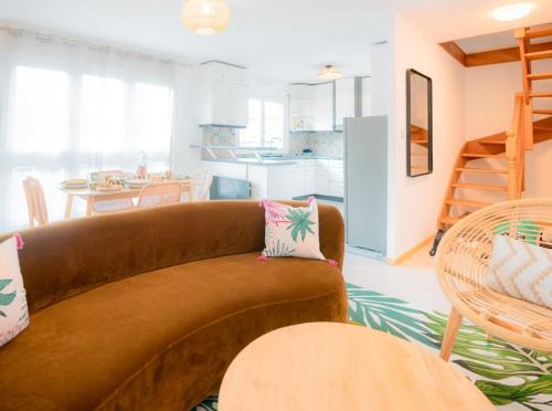 un salon avec un canapé marron et une cuisine dans l'établissement Coeur De Ville Colmar, à Colmar