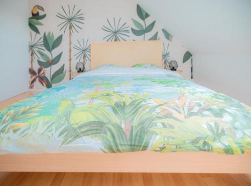 ein Bett mit einer bunten Tagesdecke mit Pflanzen drauf in der Unterkunft Coeur De Ville Colmar in Colmar
