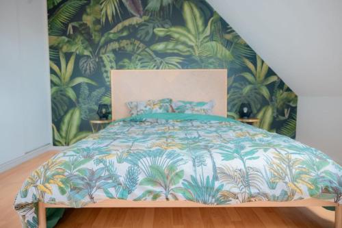une chambre avec un lit avec un papier peint tropical dans l'établissement Coeur De Ville Colmar, à Colmar