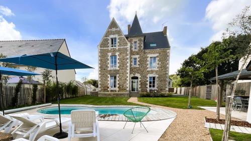 een huis met een zwembad voor een gebouw bij Manoir de la Fontaine Saint-Jean in Crossac